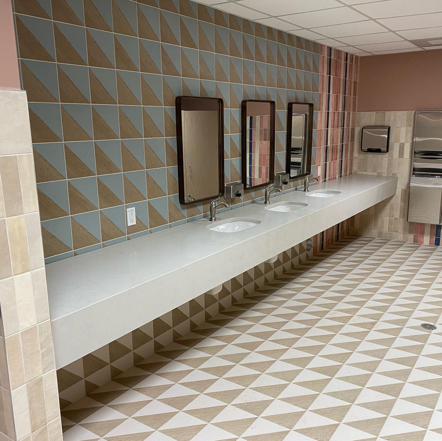 A bathroom with a row of sinks and mirrors