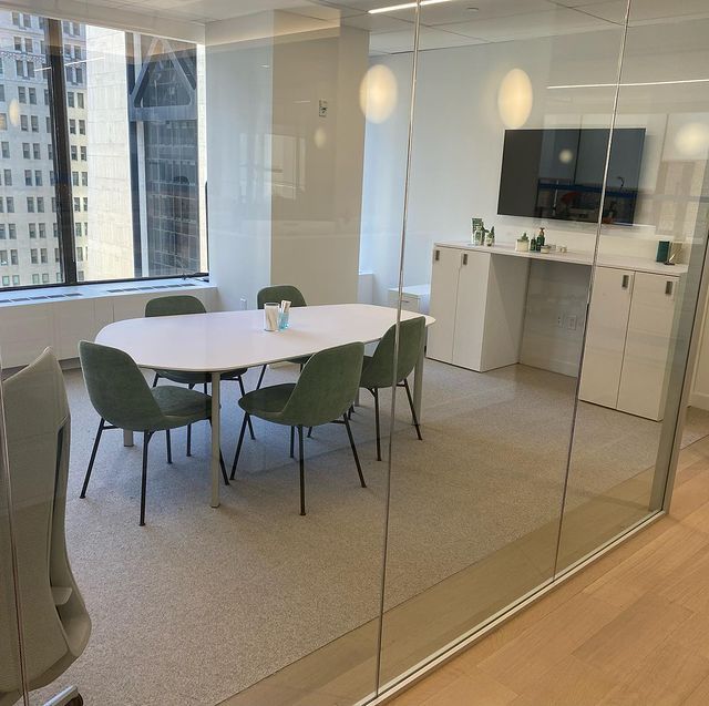 A conference room with a table and chairs behind a glass wall