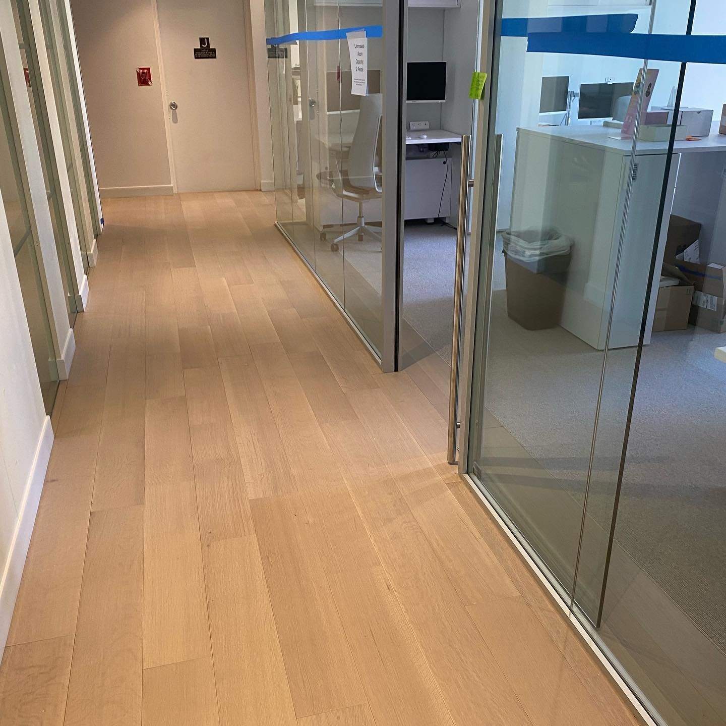 A long hallway with wooden floors and glass doors