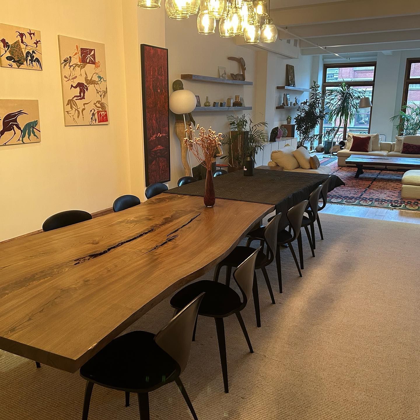 A living room with a large wooden table and chairs