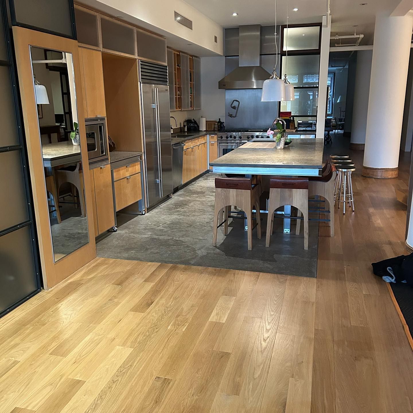 A kitchen with hardwood floors and stainless steel appliances