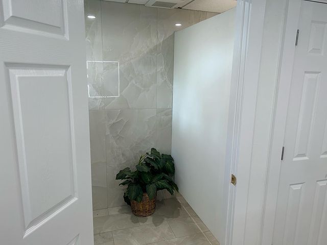 A bathroom with a plant in a basket on the floor.