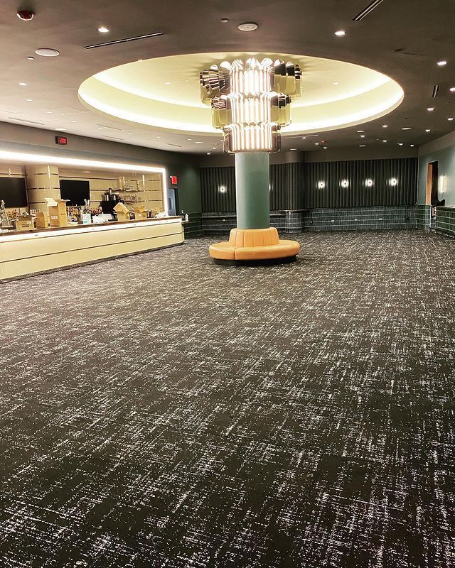 A large lobby with a couch and a chandelier.