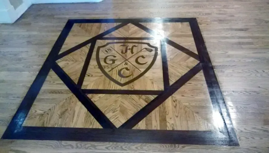 A wooden floor with a monogram on it