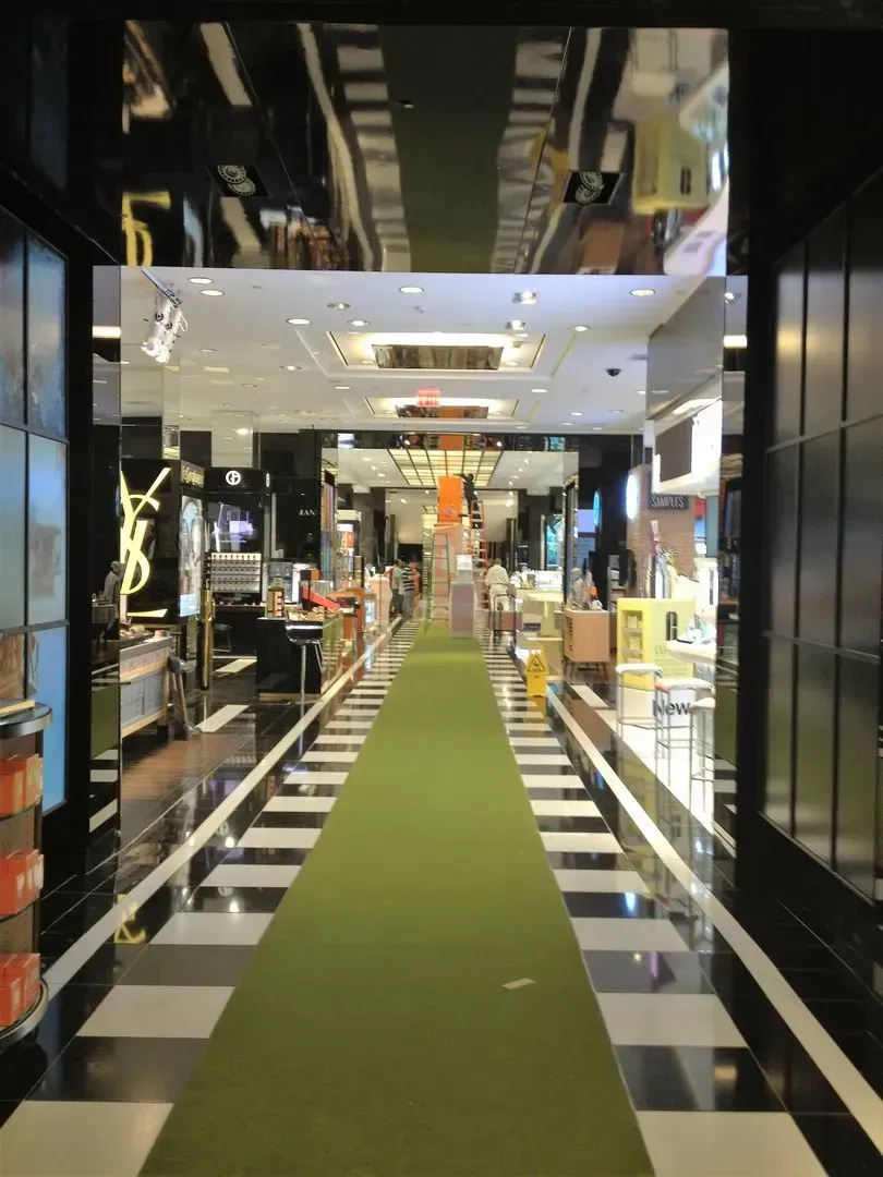 A very long hallway with a green carpet