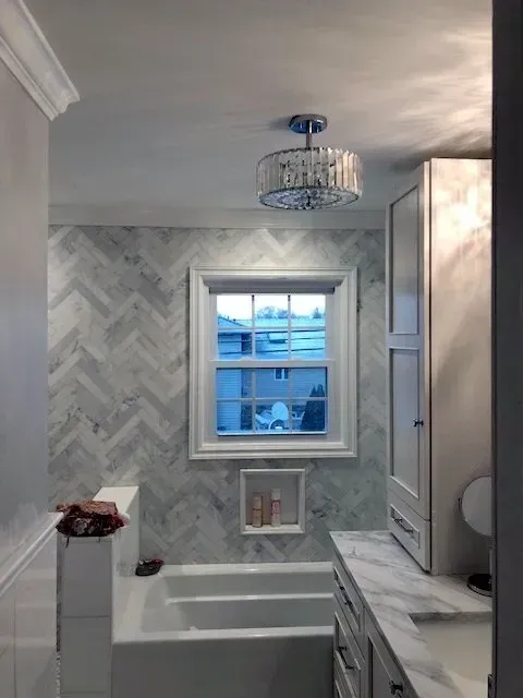 A bathroom with a bathtub a sink and a window