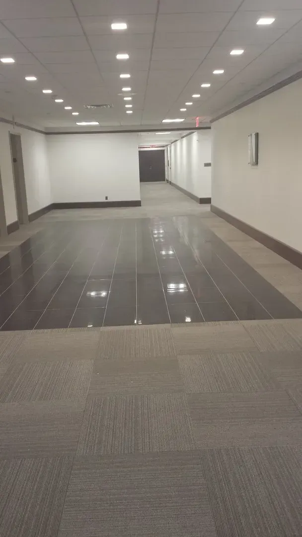 An empty hallway with a tiled floor and white walls.