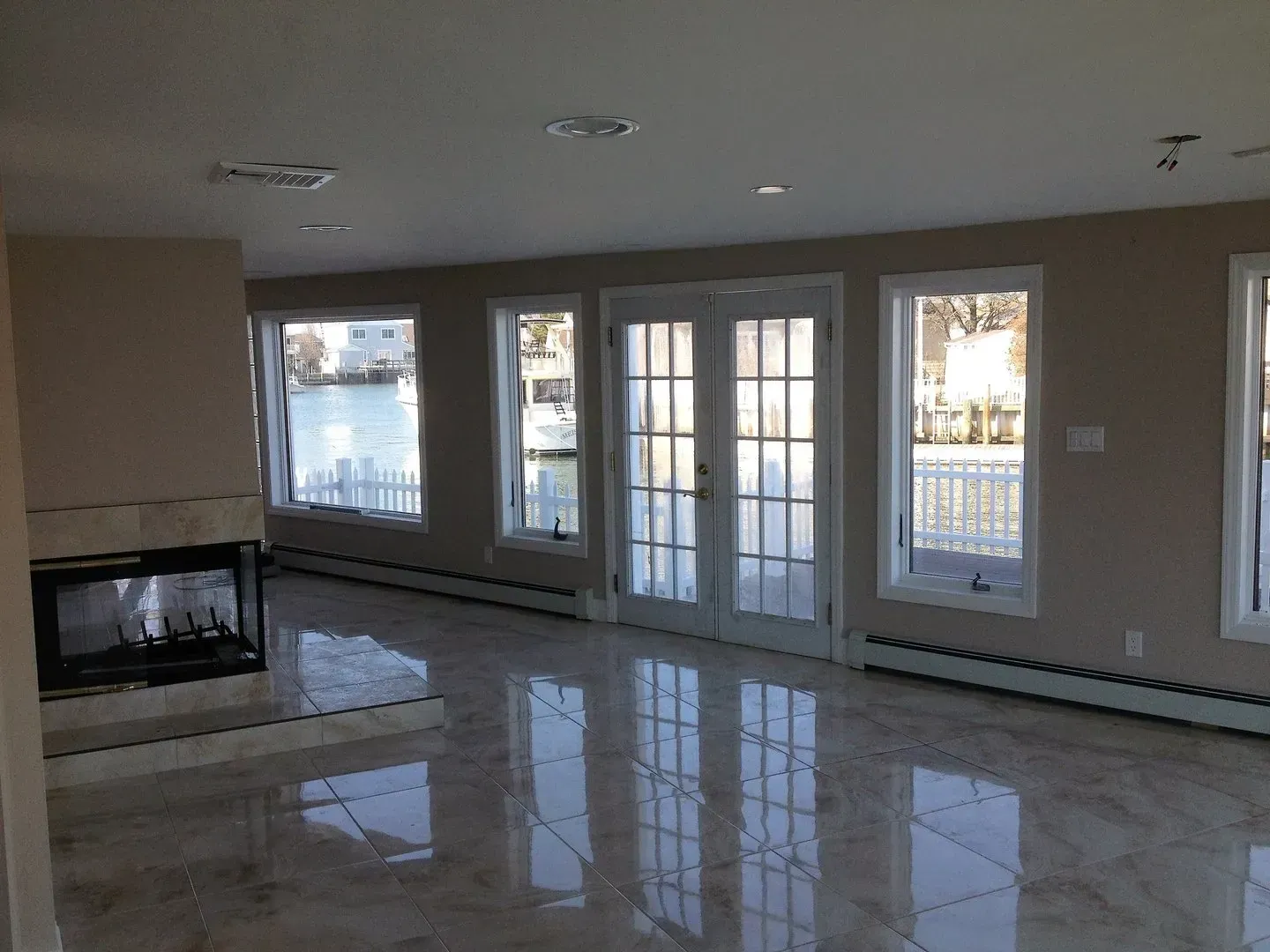 A living room with a fireplace and lots of windows