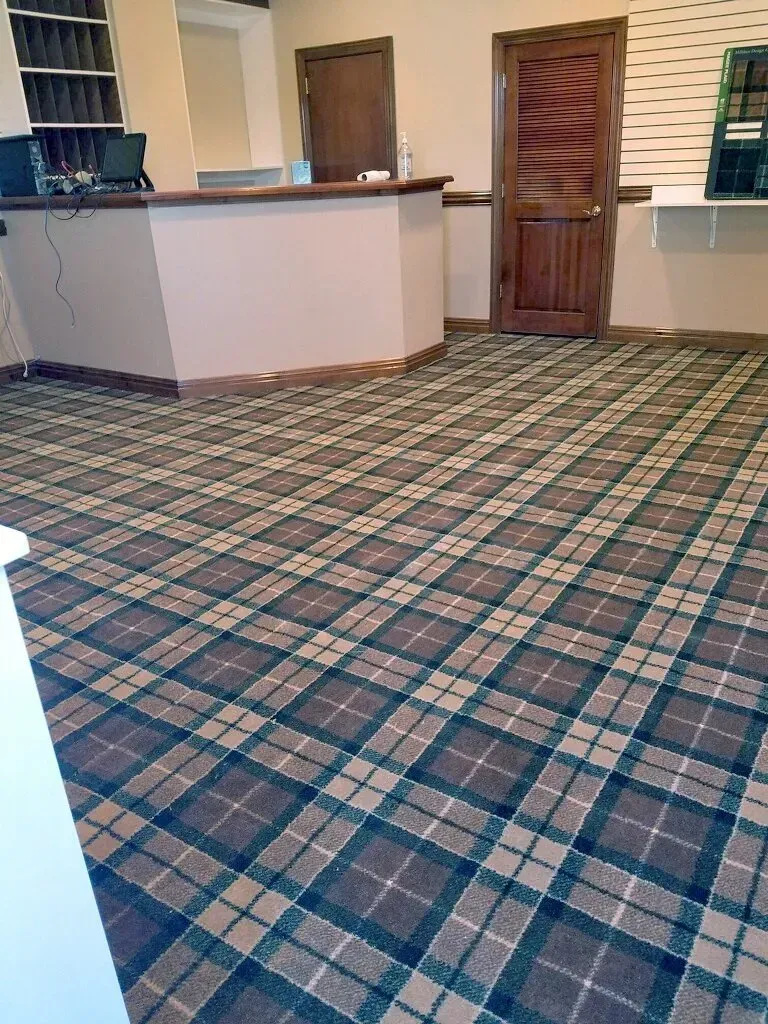 A room with a plaid carpet and a wooden counter.