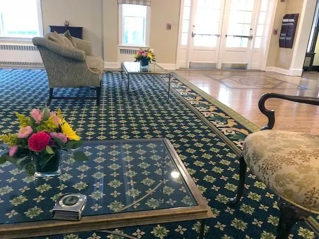 A living room with a glass table and a vase of flowers on it