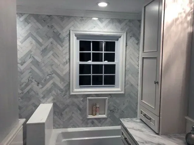 A bathroom with a bathtub and a window