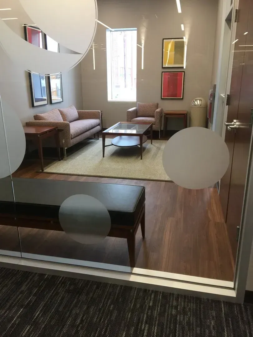 A living room with a couch , chairs , a coffee table and a bench.