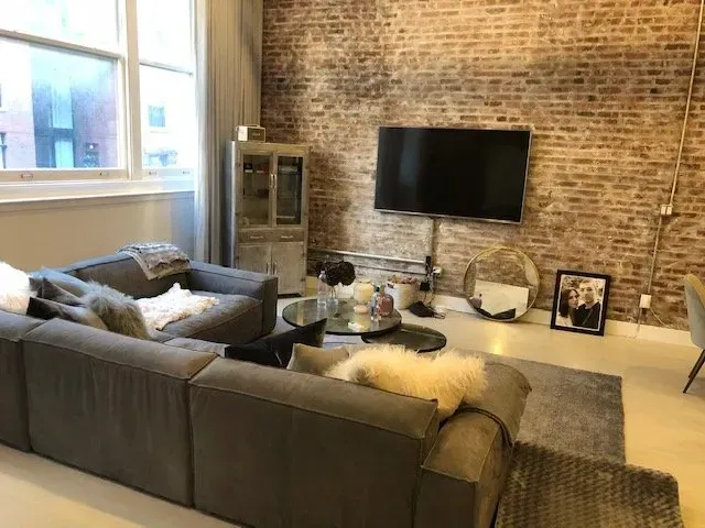A living room with a couch , chair , table and television.