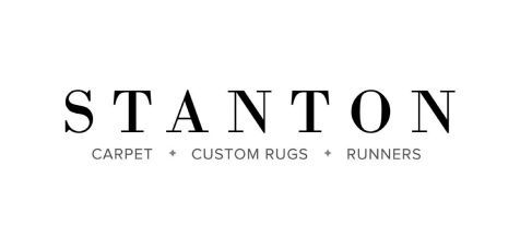 A black and white logo for stanton carpet , custom rugs , and runners.