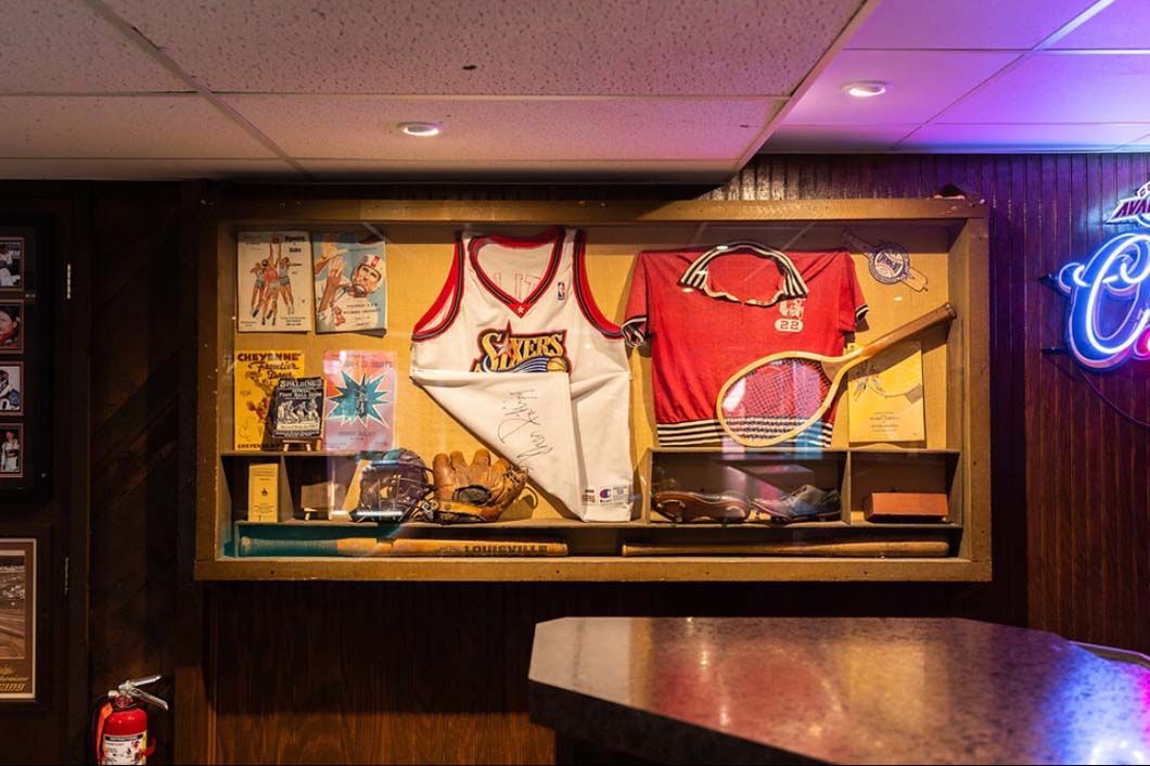 A display case filled with sports memorabilia is hanging on a wall.