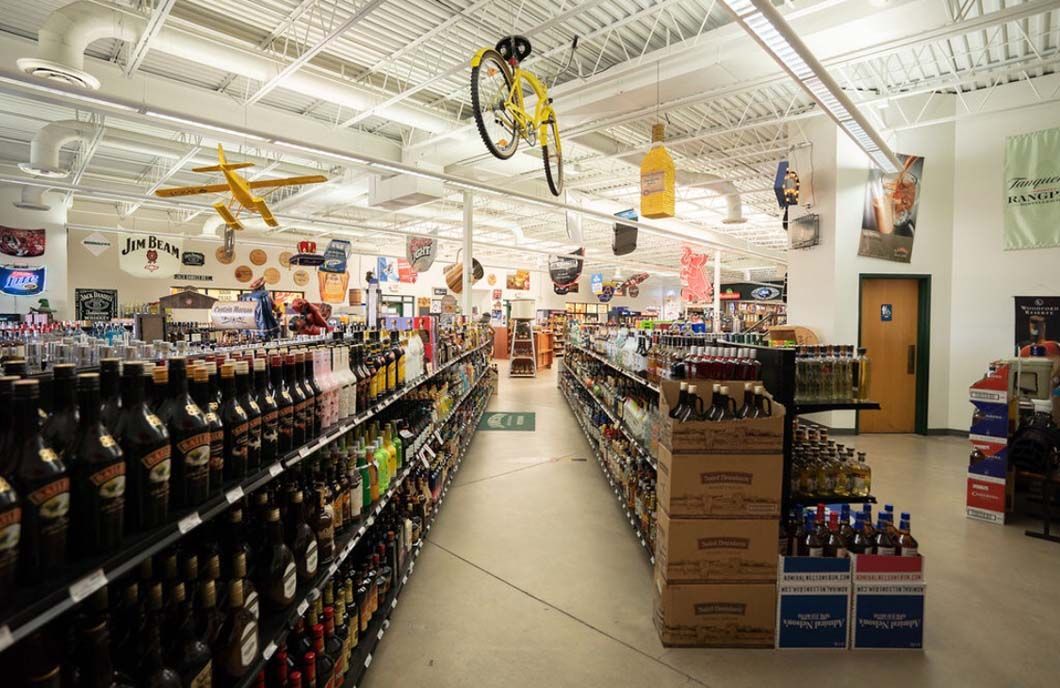 A blurred image of a liquor store with a bicycle hanging from the ceiling.
