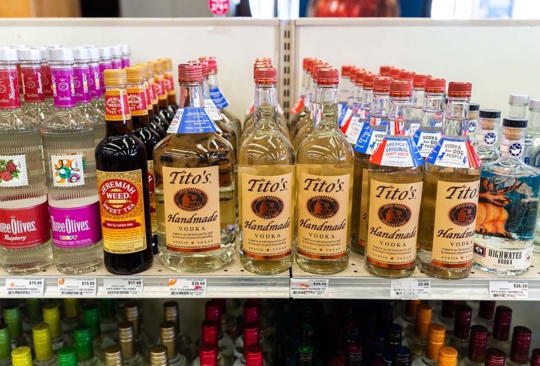 A shelf filled with bottles of alcohol in a store.