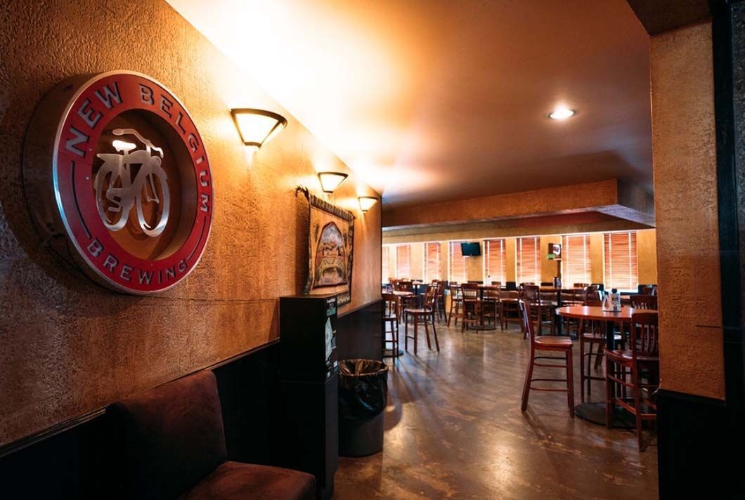 A restaurant with tables and chairs and a sign on the wall that says new york
