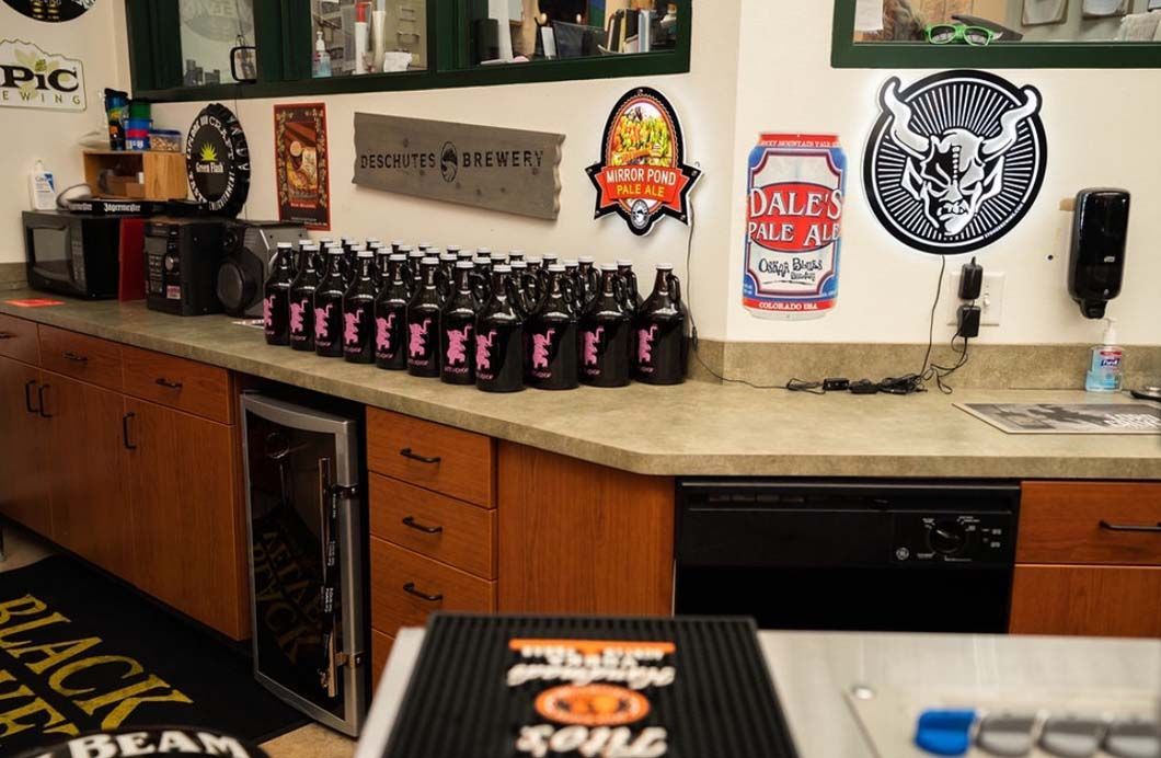A kitchen with a lot of bottles of beer on the counter