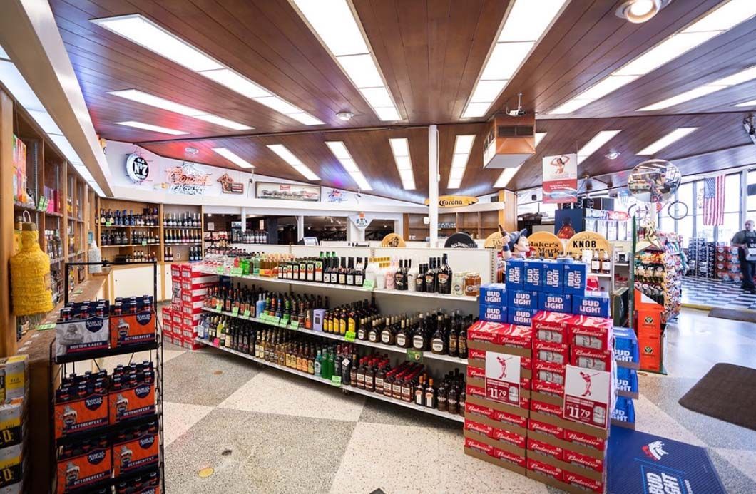 A liquor store filled with lots of shelves and boxes of beer.