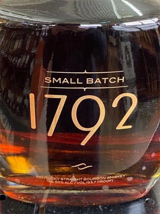 A bottle of small batch 1792 bourbon whiskey is sitting on a table.