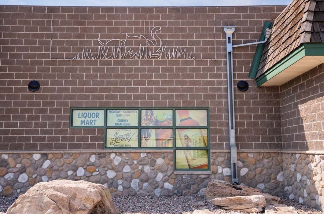 A brick building with a window that says liquor post