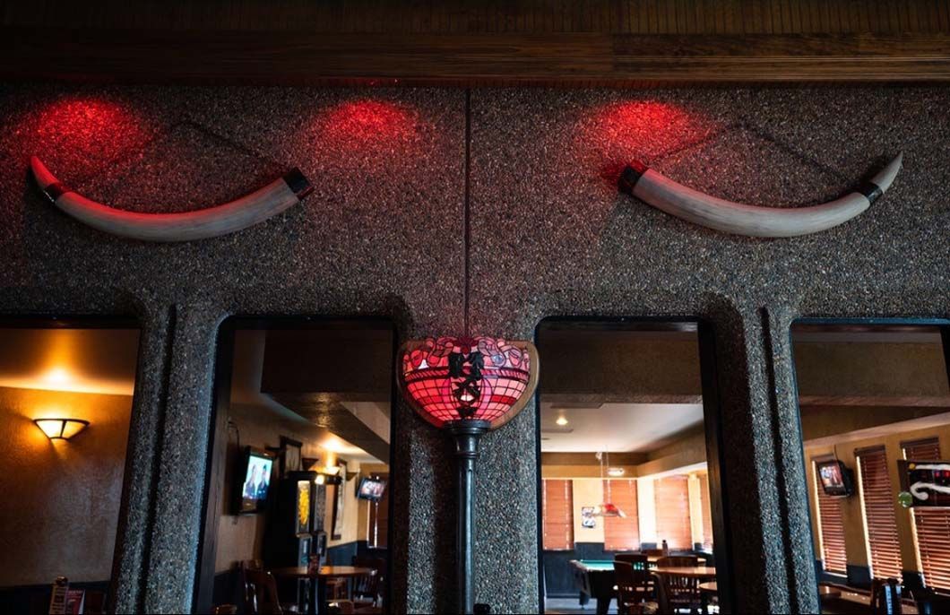 A restaurant with a statue of a bull on the wall.