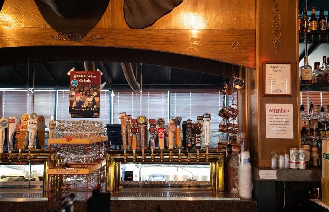 A bar filled with lots of beer taps and bottles.