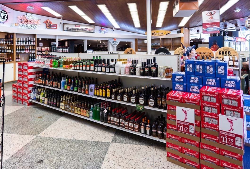 A grocery store filled with lots of bottles and boxes of beer.