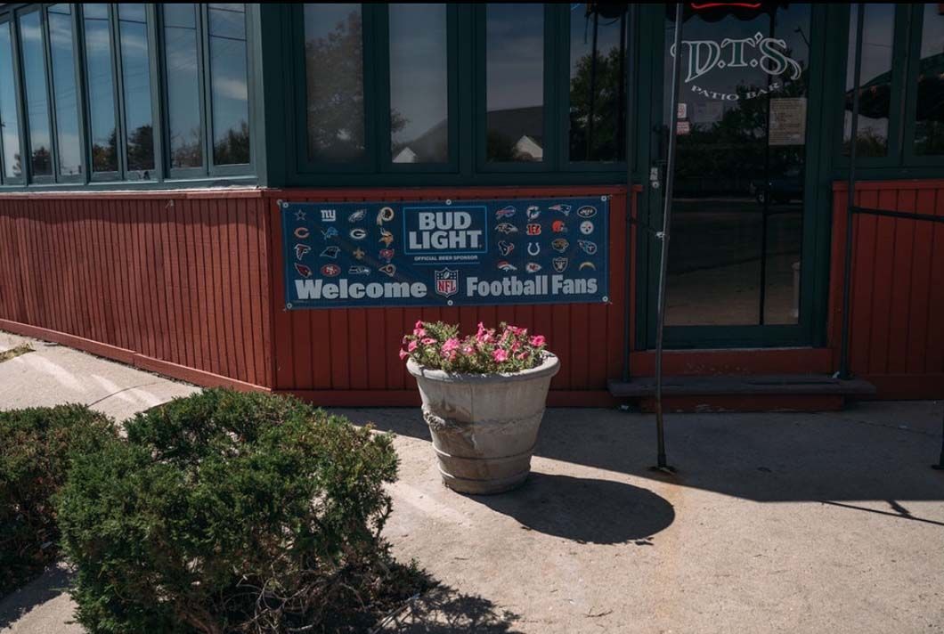 A bud light sign is on the side of a building.