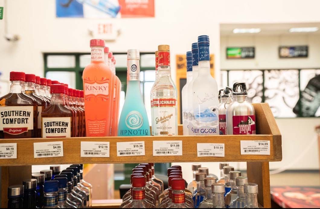 A shelf filled with bottles of liquor in a store.