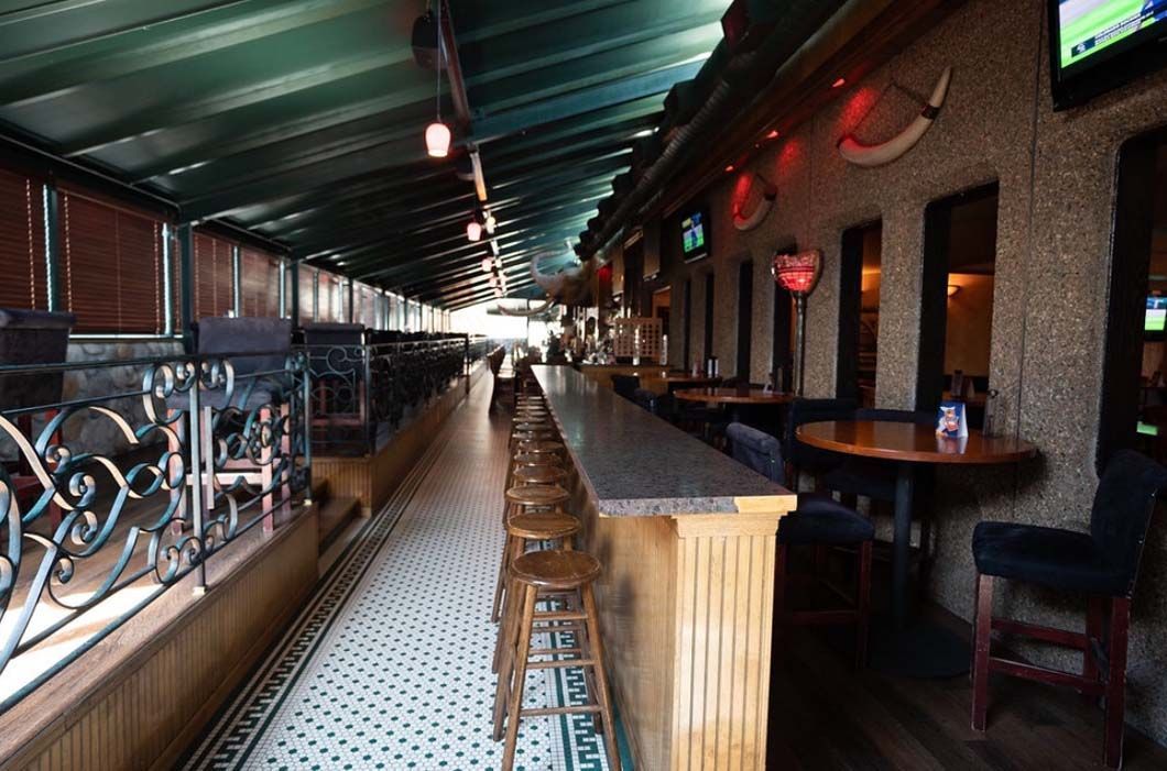 A long hallway with tables and chairs in a restaurant.