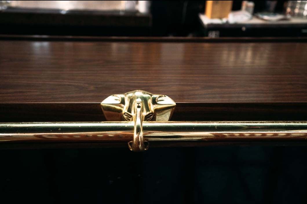 A close up of a gold railing on a wooden table.