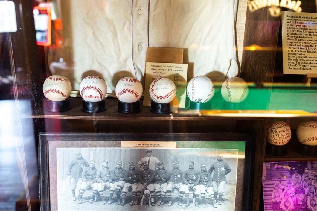 A group of baseballs are on display in a glass case