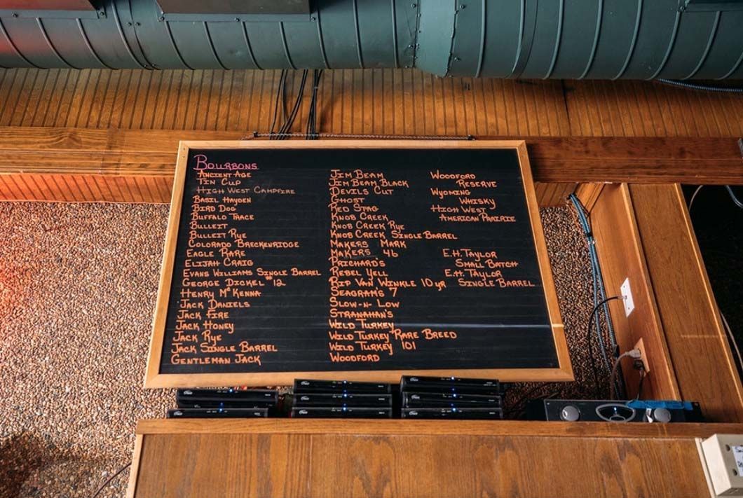 A wooden table with a chalkboard on top of it