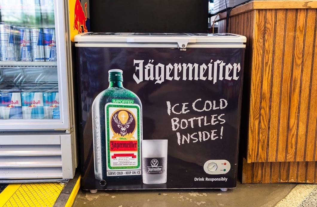 A freezer filled with jagermeister ice cold bottles inside.