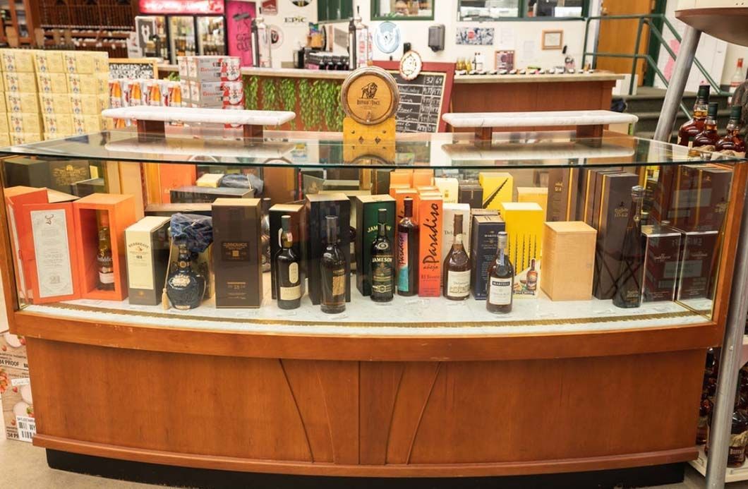 A display case filled with bottles and boxes of alcohol in a store.
