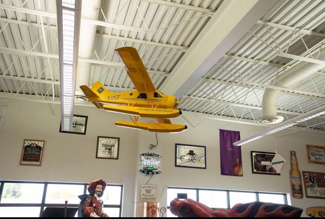 A yellow airplane is hanging from the ceiling in a room