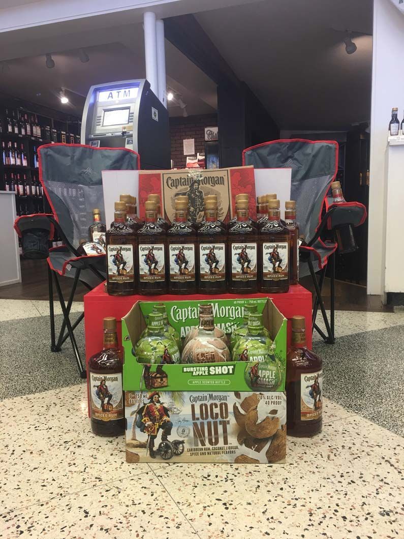 A bunch of bottles of alcohol are sitting on a table in a room.