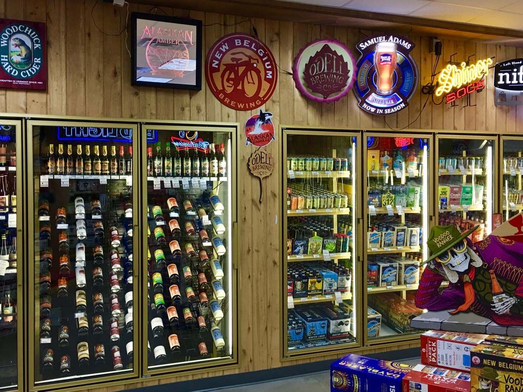 A liquor store with a lot of bottles in the freezers
