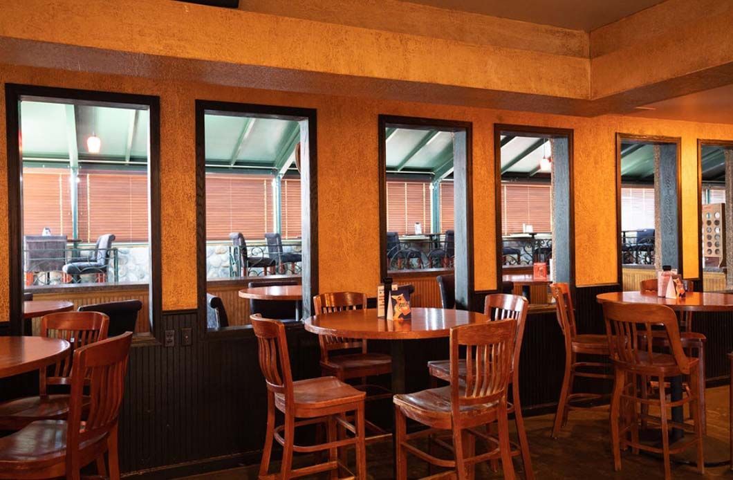 A restaurant with tables and chairs and lots of windows