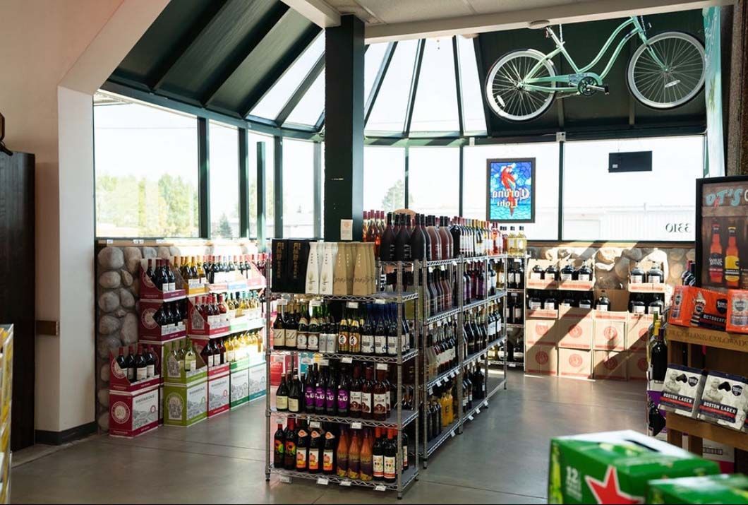 A store filled with lots of bottles of alcohol and a bicycle on the wall.