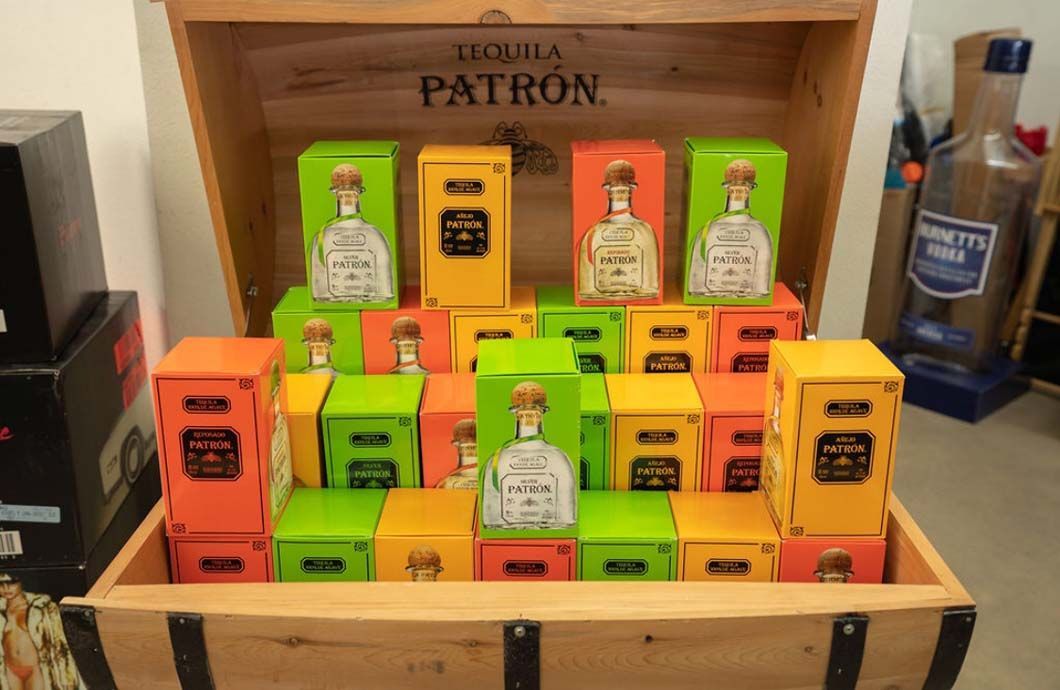 A wooden trunk filled with boxes of patron tequila