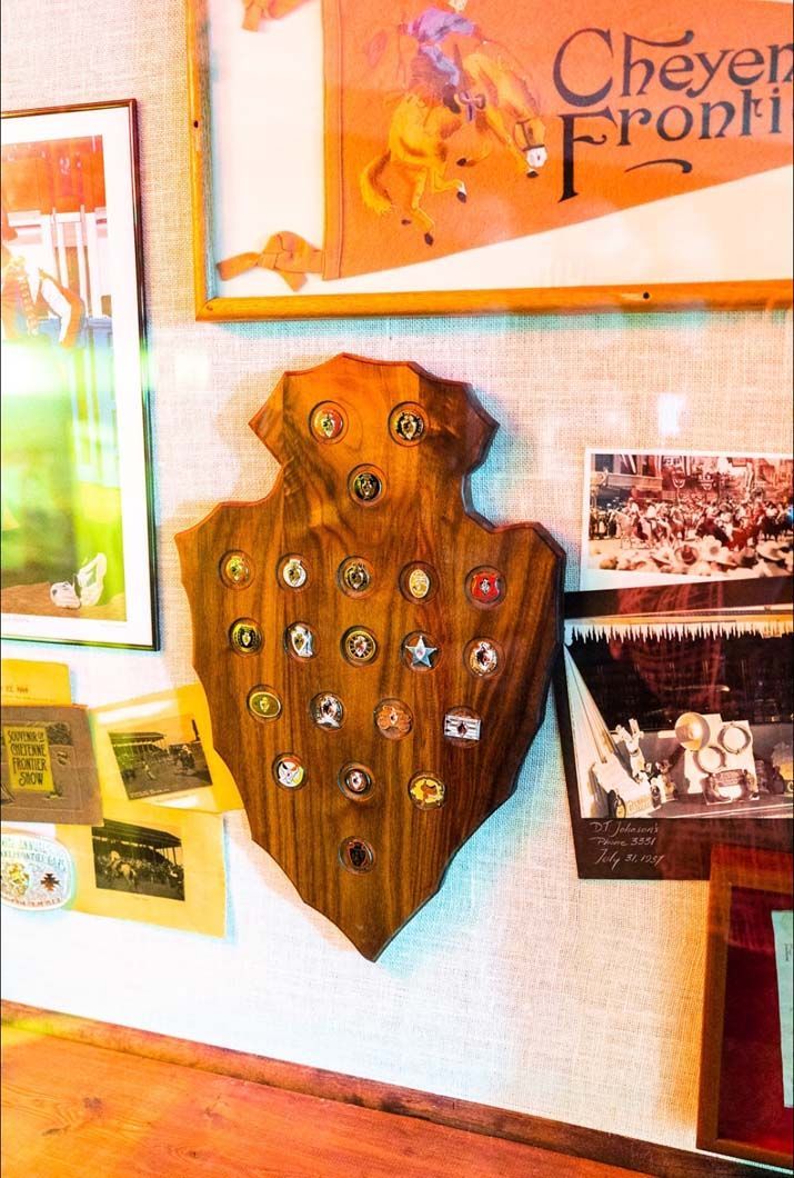 A wooden plaque with buttons on it is hanging on a wall
