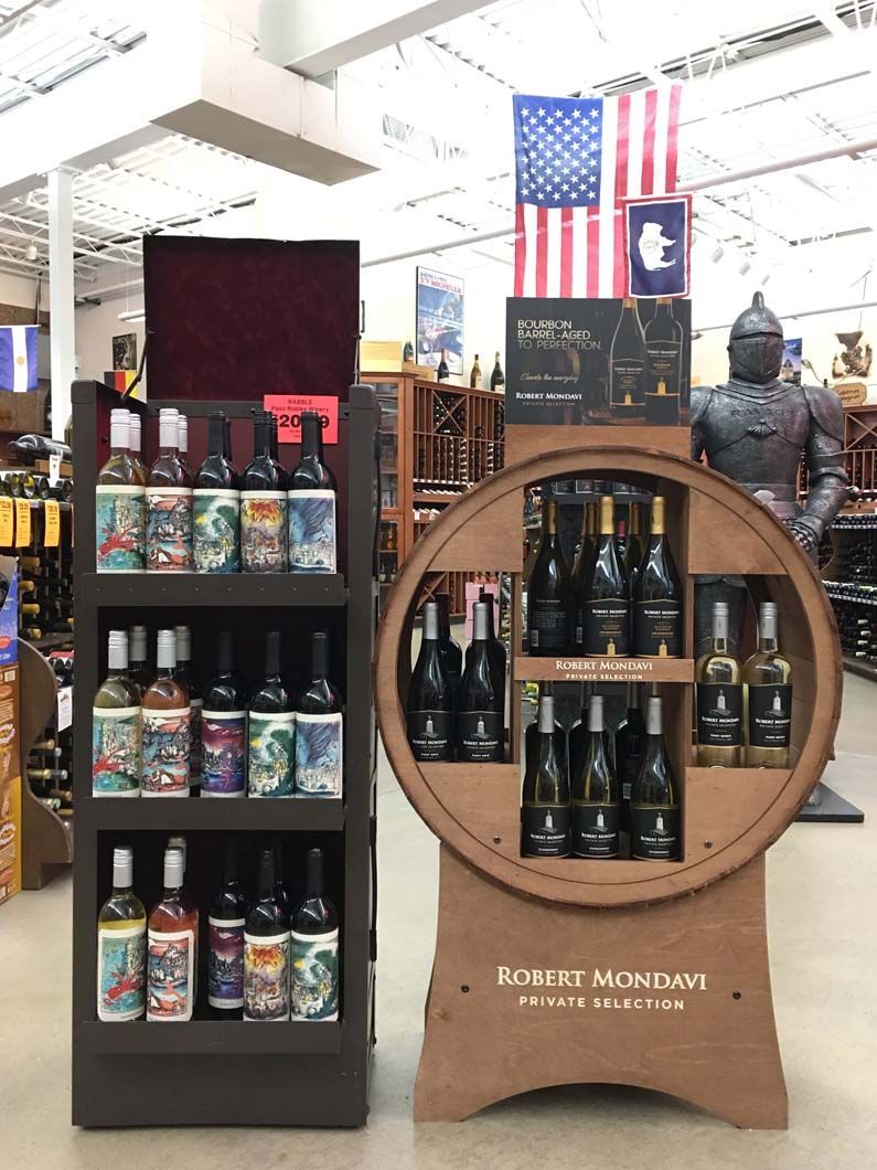A display of wine bottles in a store with an american flag in the background