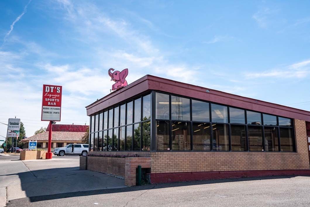 A large building with a pink elephant on top of it.