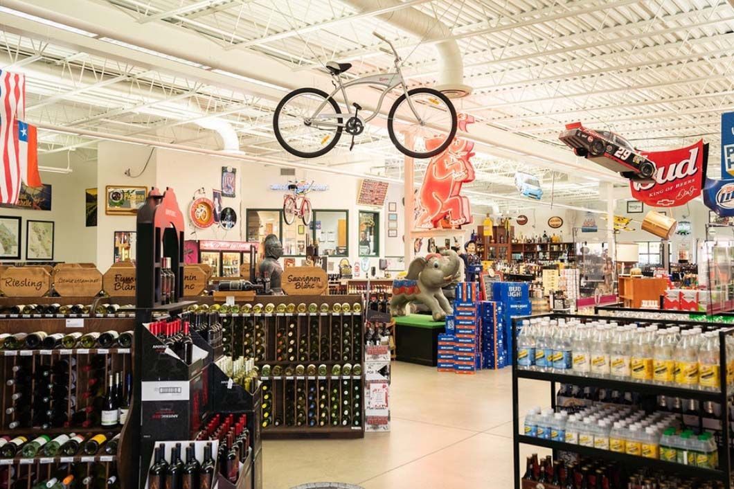 A bicycle is hanging from the ceiling of a store.
