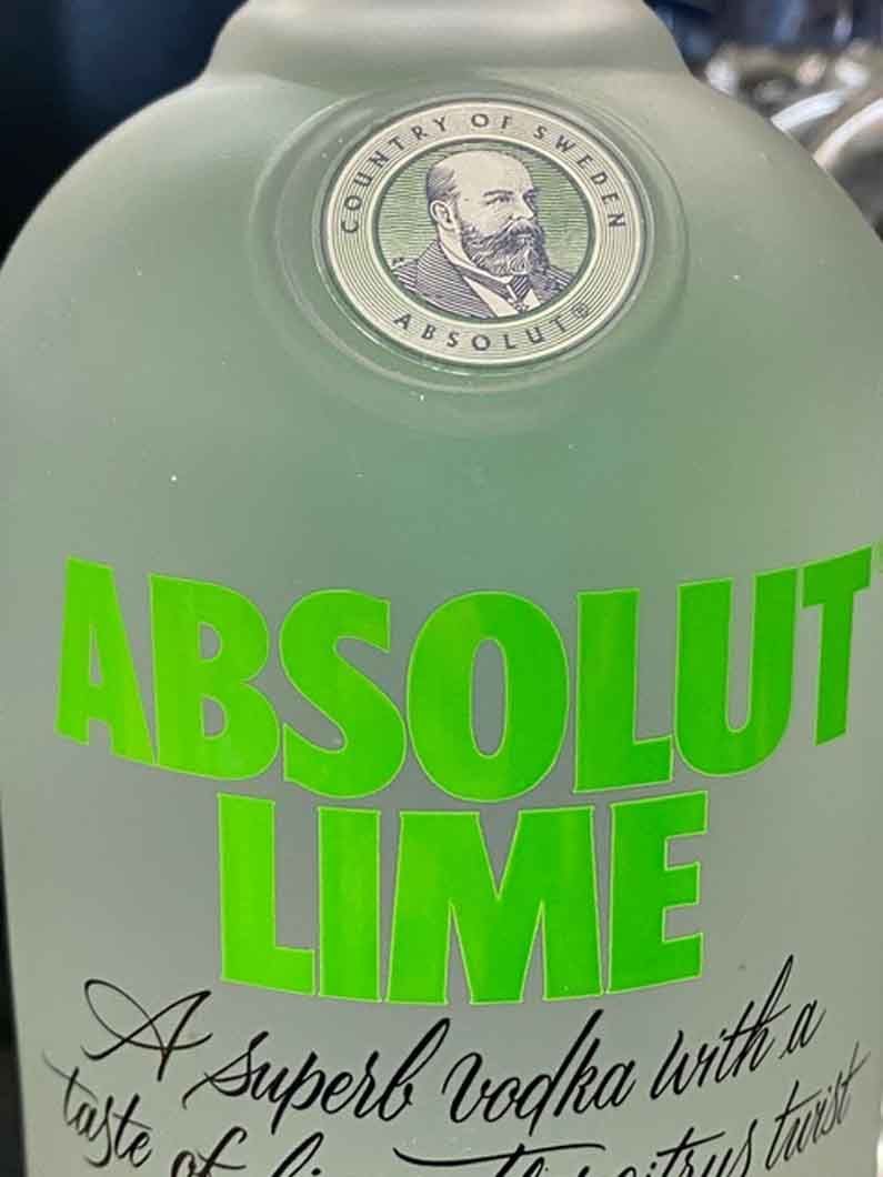 A close up of a bottle of absolut lime vodka