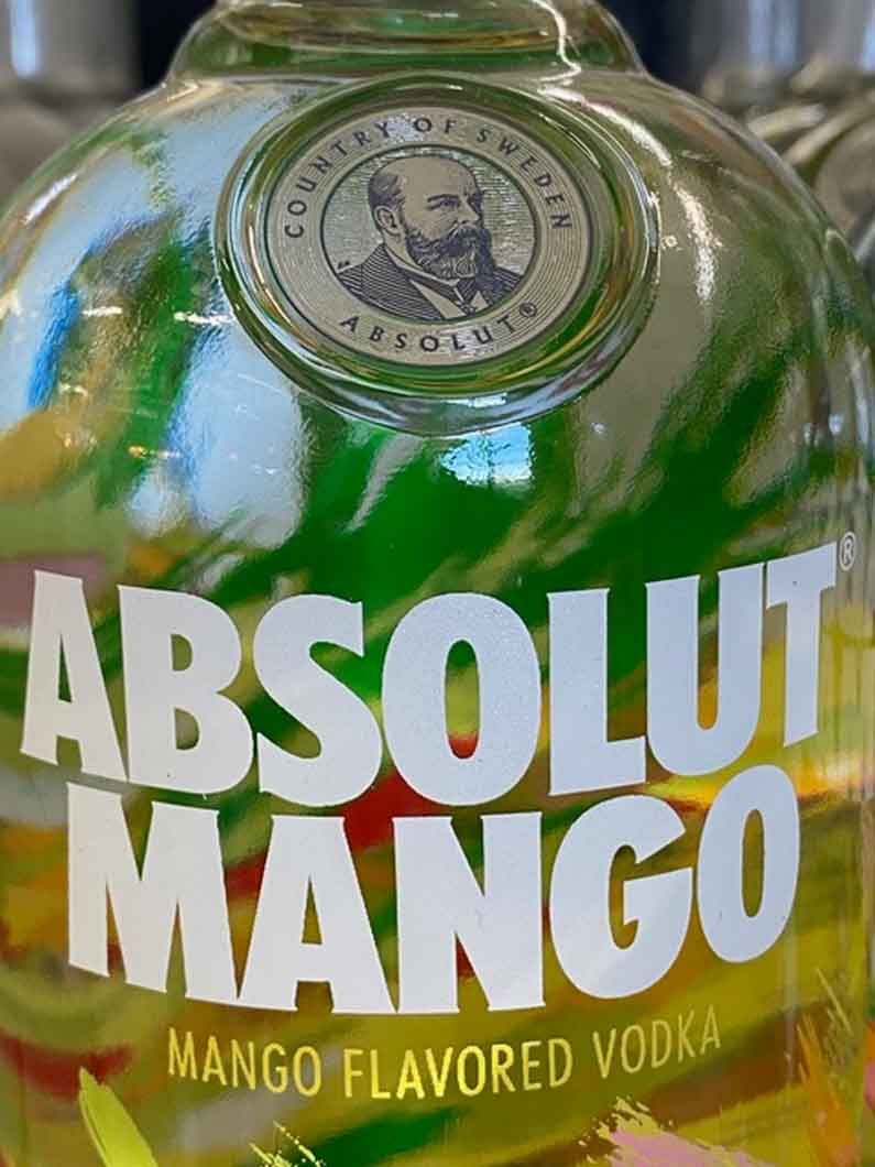 A close up of a bottle of absolut mango vodka