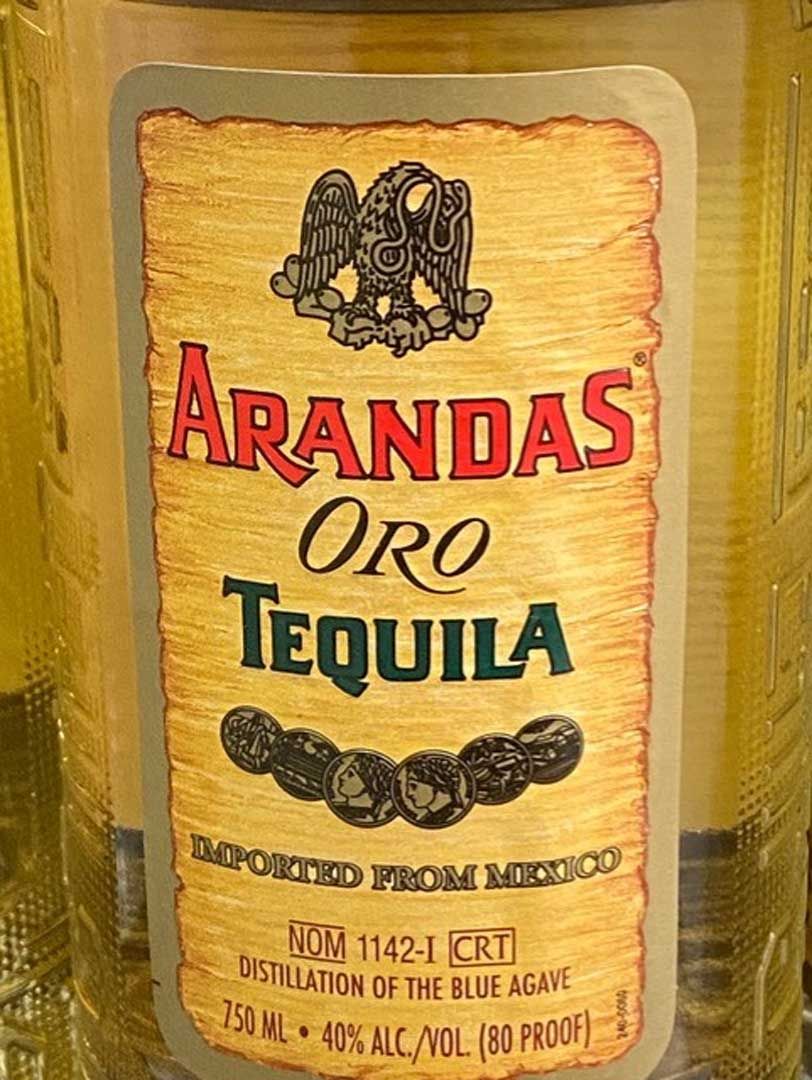 A bottle of arandas oro tequila is sitting on a table.